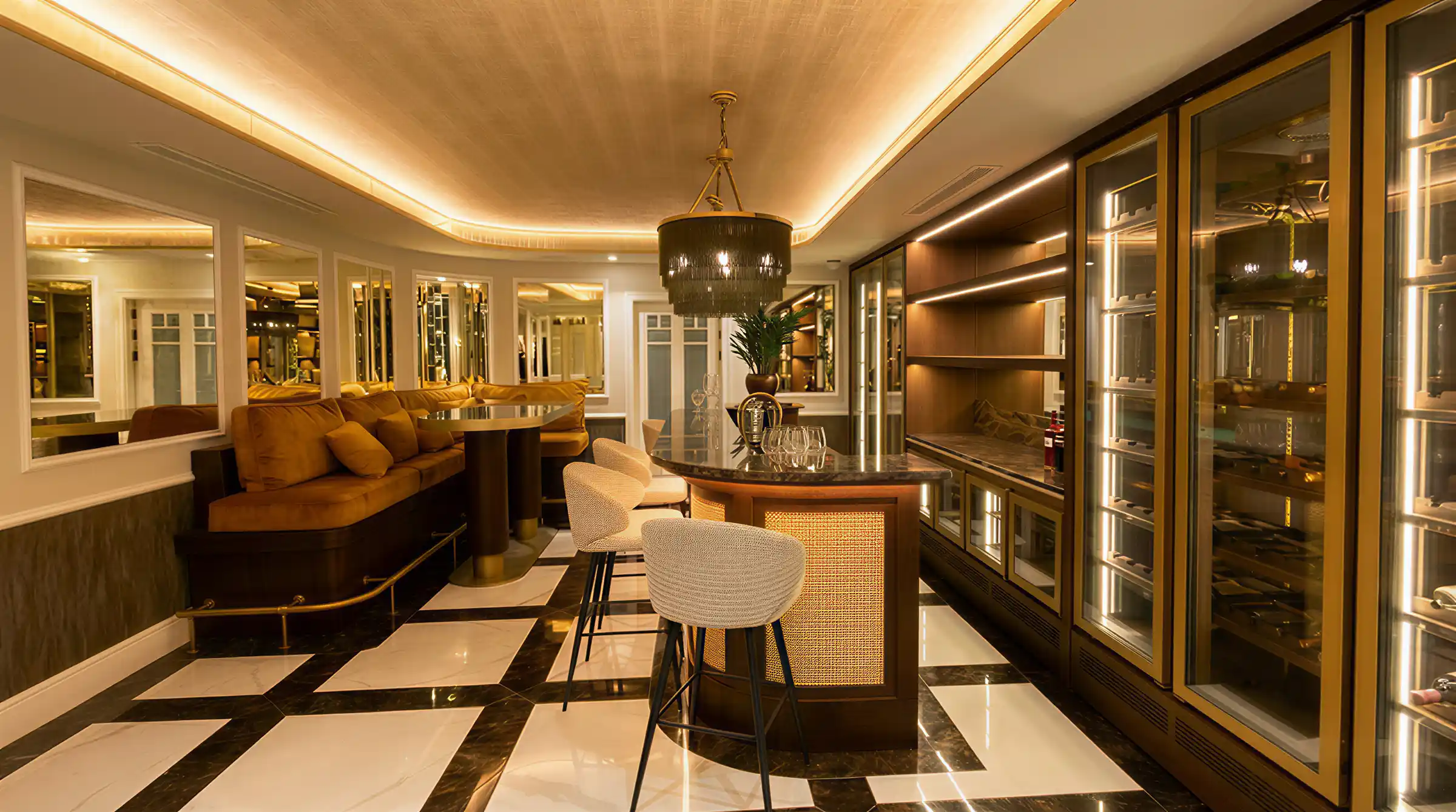 Basement bar and lounge with cove lighting and polished stone floor in a Marbella villa